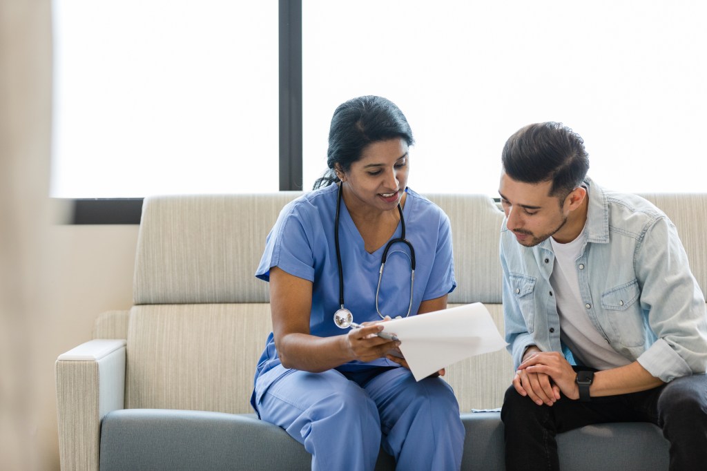 Young man and female doctor review the medical chart together