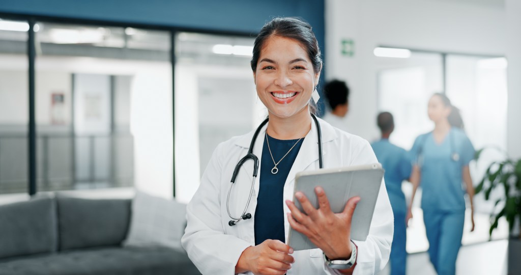Happy woman or doctor face in busy hospital with tablet for healthcare services, leadership and career mindset. Portrait of medical professional or female on telehealth app for clinic job management