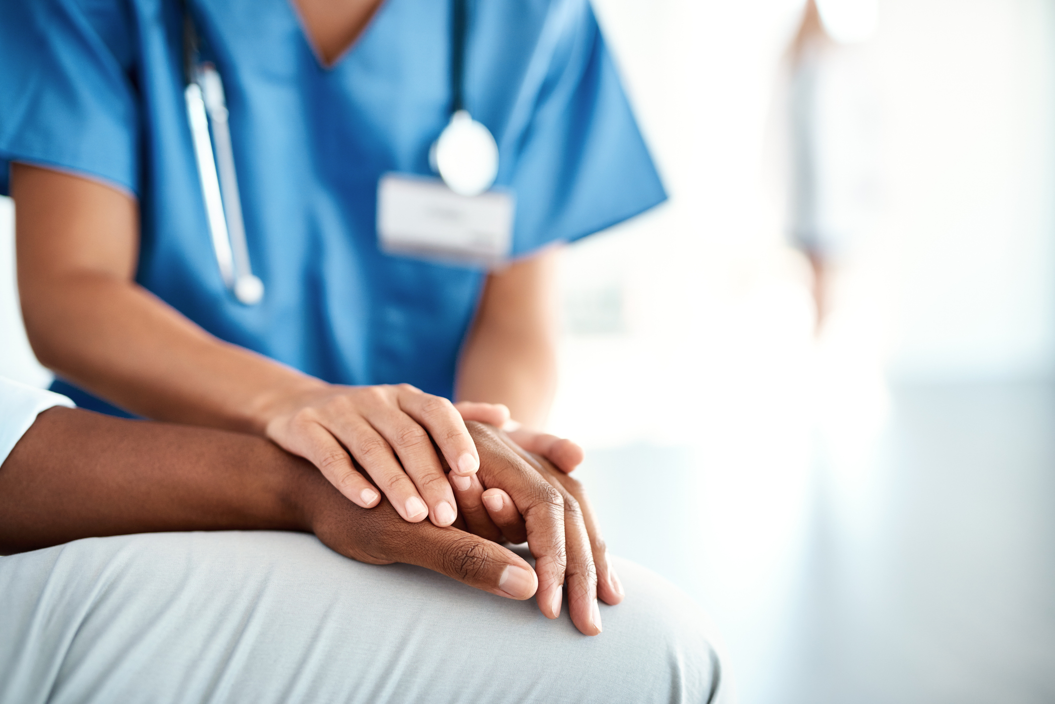 female nurse holding patient's hand