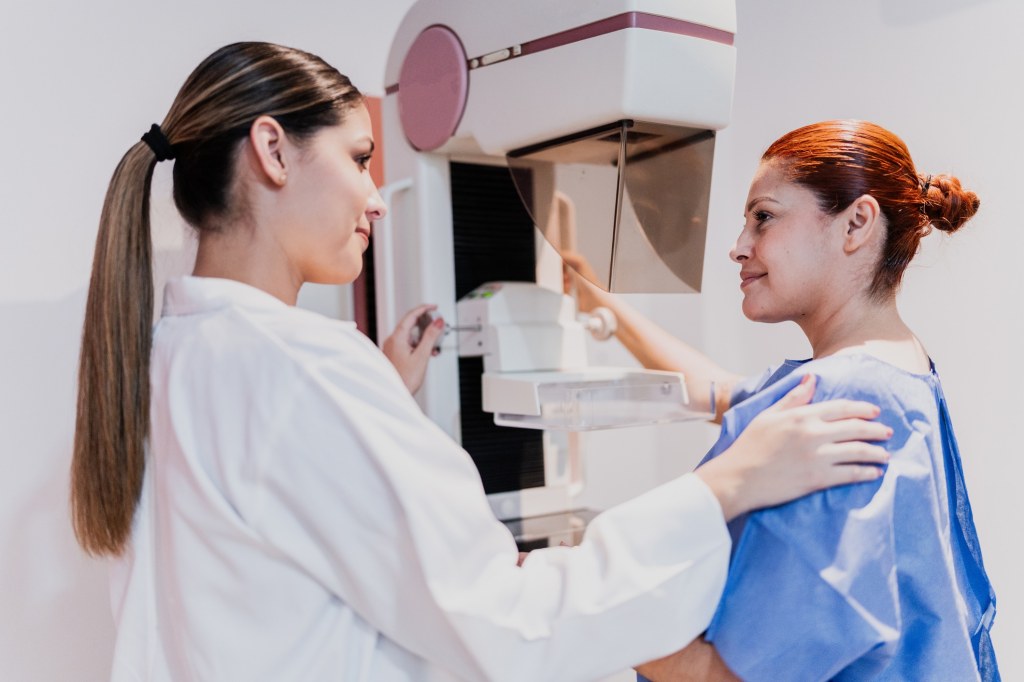 A woman receives a mammogram, guided by a health care professional, representing expert breast cancer screening and prevention services in Birmingham, Alabama.