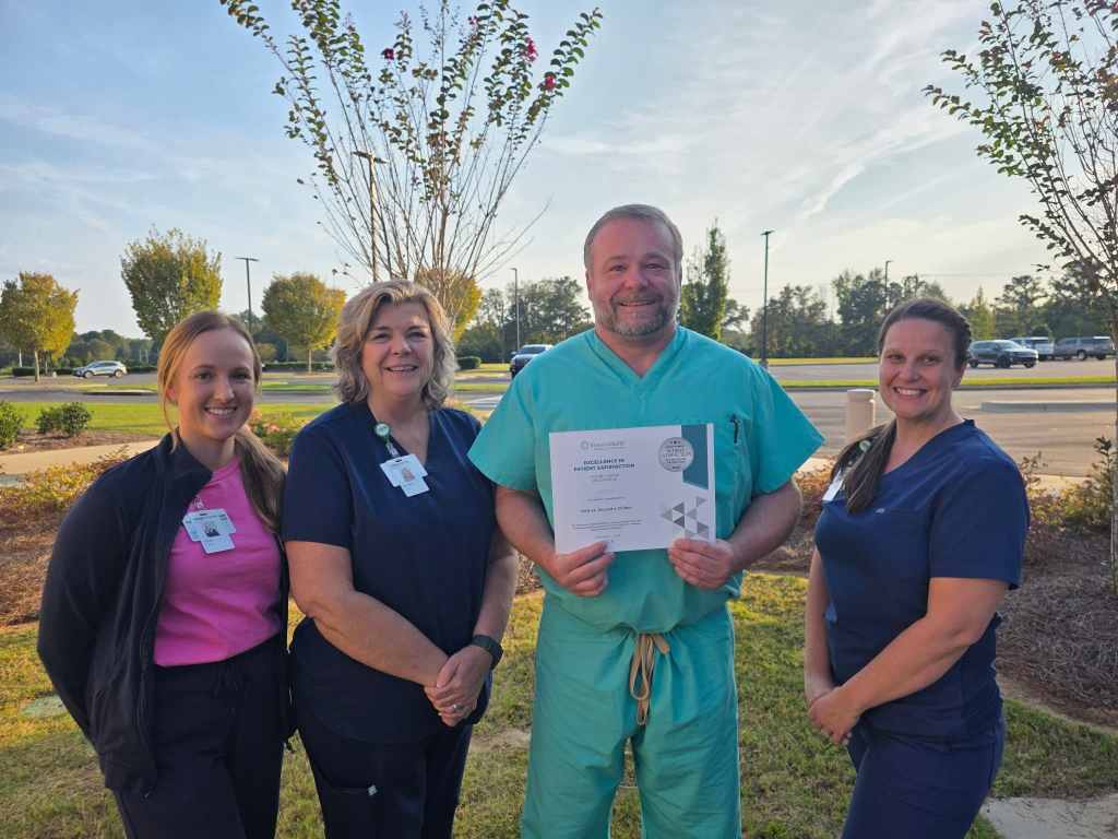 UAB St. Vincent’s Chilton Wound Center care team stands outside the hospital in Clanton, Alabama, holding an Excellence in Patient Satisfaction Award from RestorixHealth, recognizing superior wound care and patient experience.