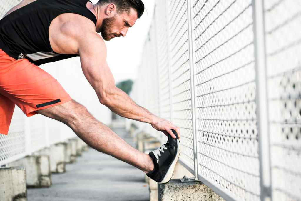 Runner stretching ankles after working out