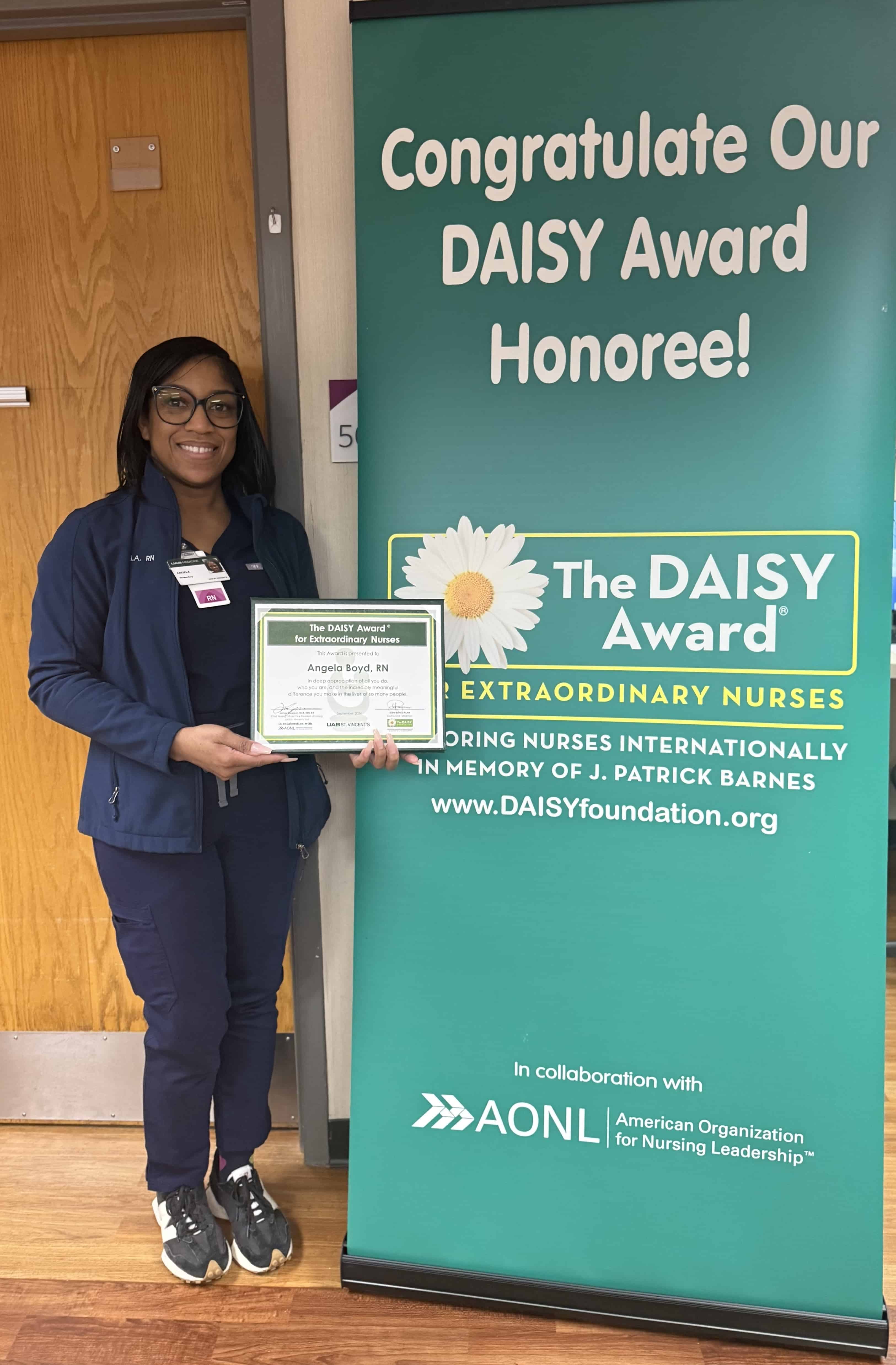 Angela Boyd, RN, stands at UAB St. Vincent's East holding her DAISY Award