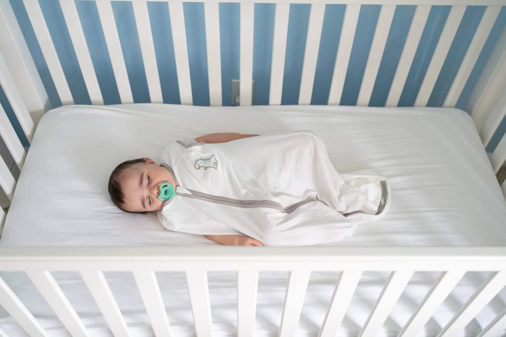 baby sleeping in crib following safe sleep measures