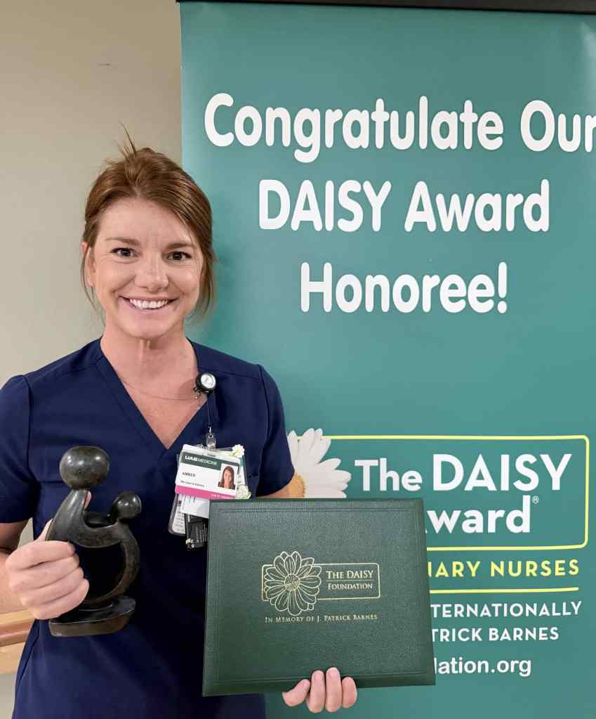 Amber Pearson, a labor and delivery nurse at UAB St. Vincent's Birmingham stands with her DAISY award