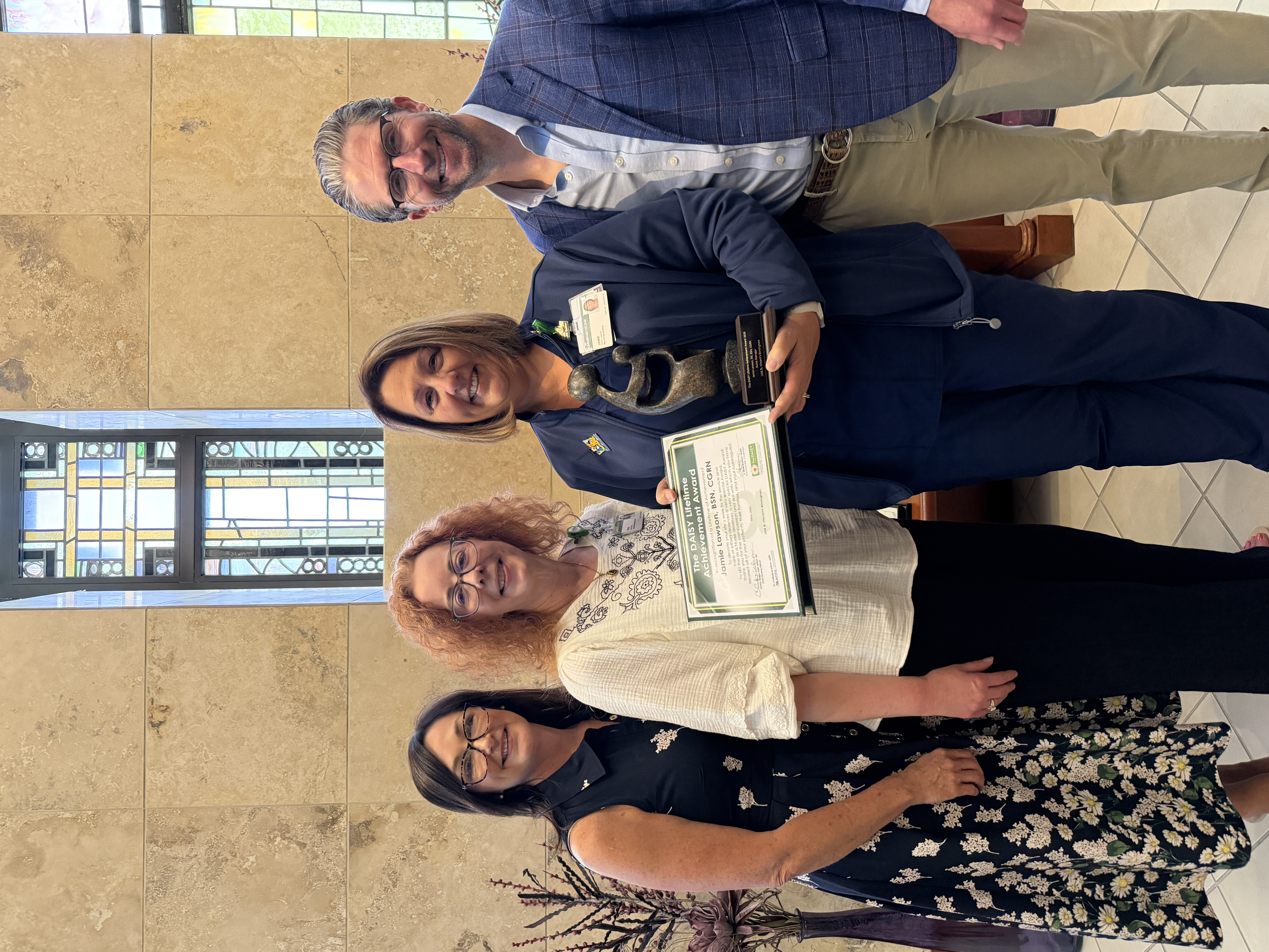 Jamie Lawson stands with her DAISY Lifetime Achievement Award at UAB St. Vincent's 