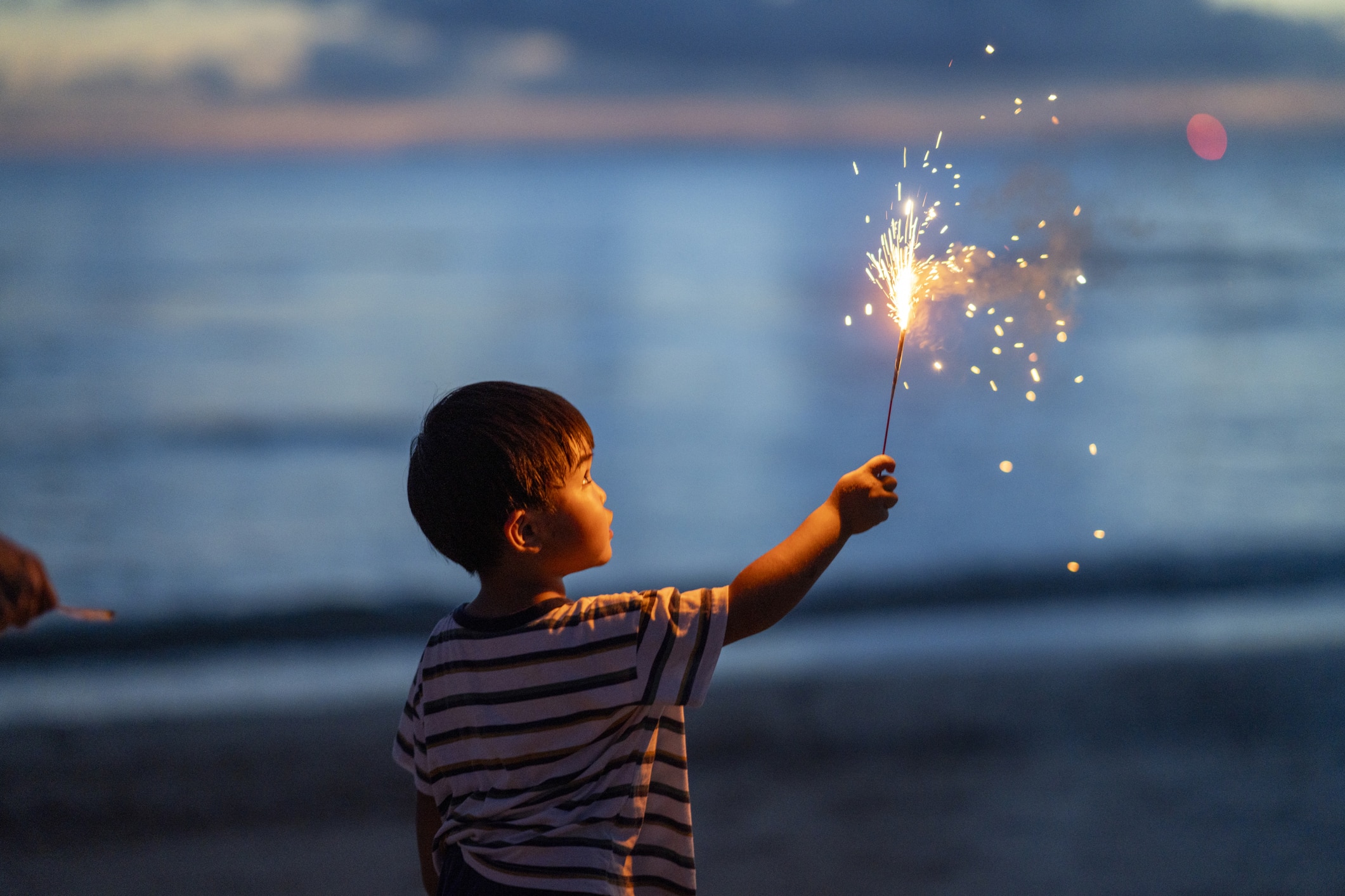 Young boy holding a sparkler firework