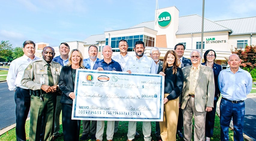 group standing with large check