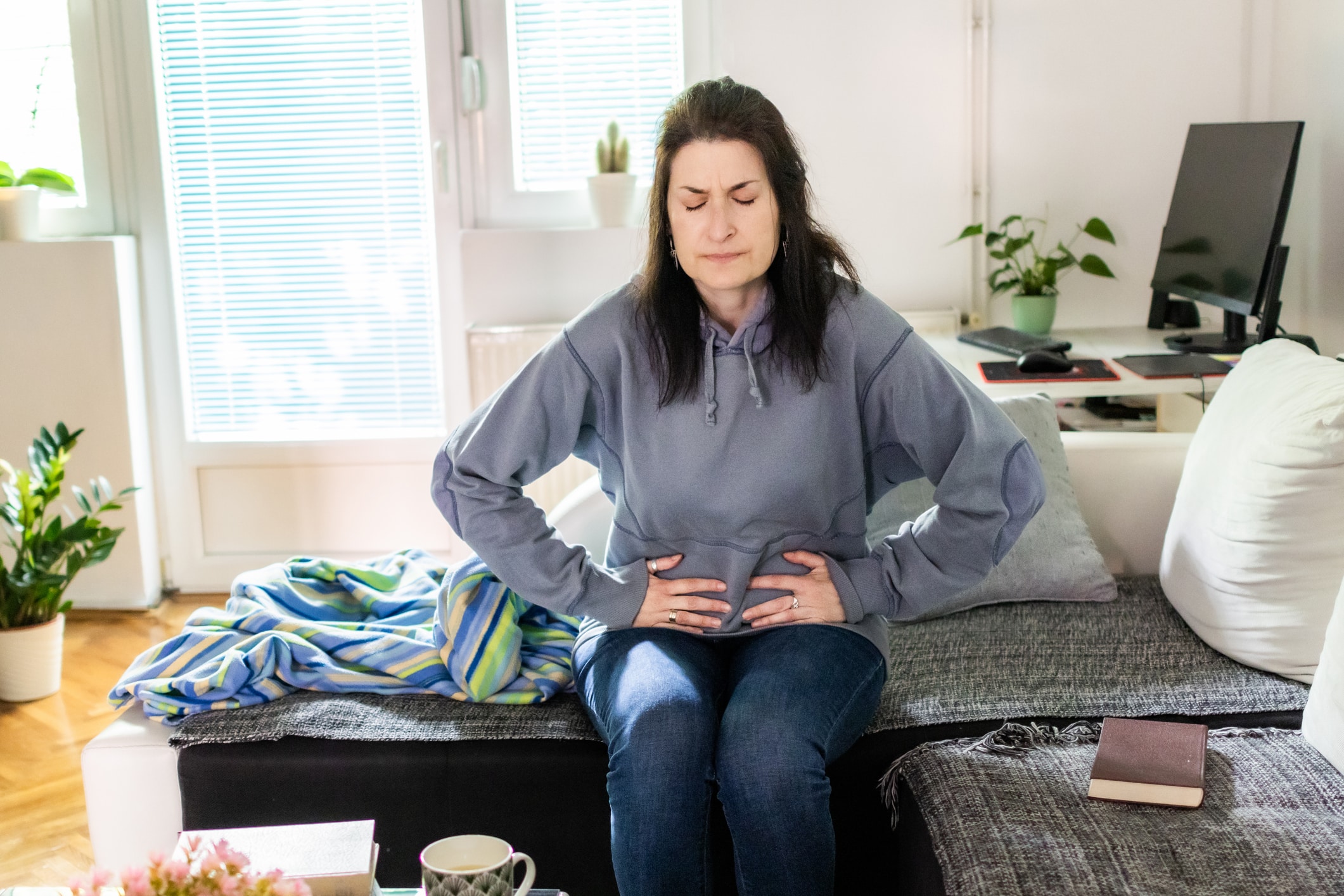 Women with uterine fibroids. Woman is suffering from stomach ache at home. 