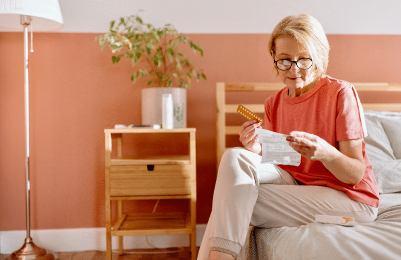 woman sitting on bed reading medical test results