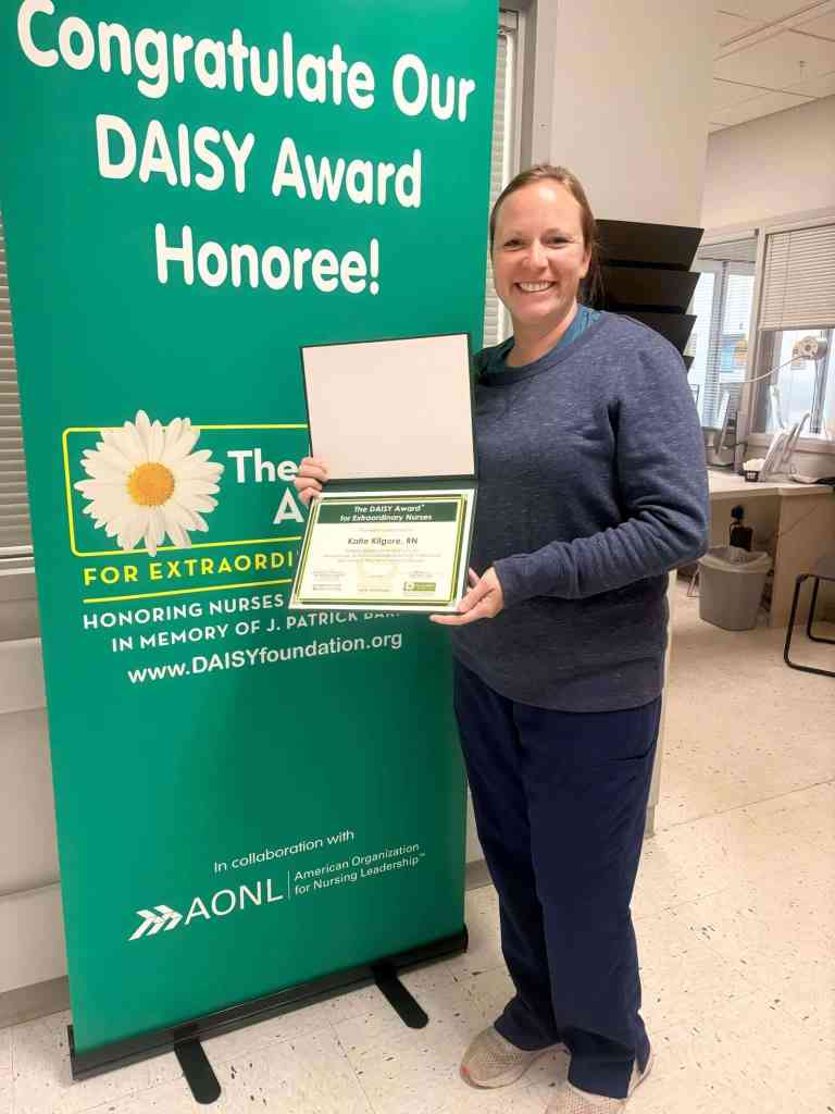 Katie Kilgore, RN stands with her DAISY Award at UAB St. Vincent's Blount