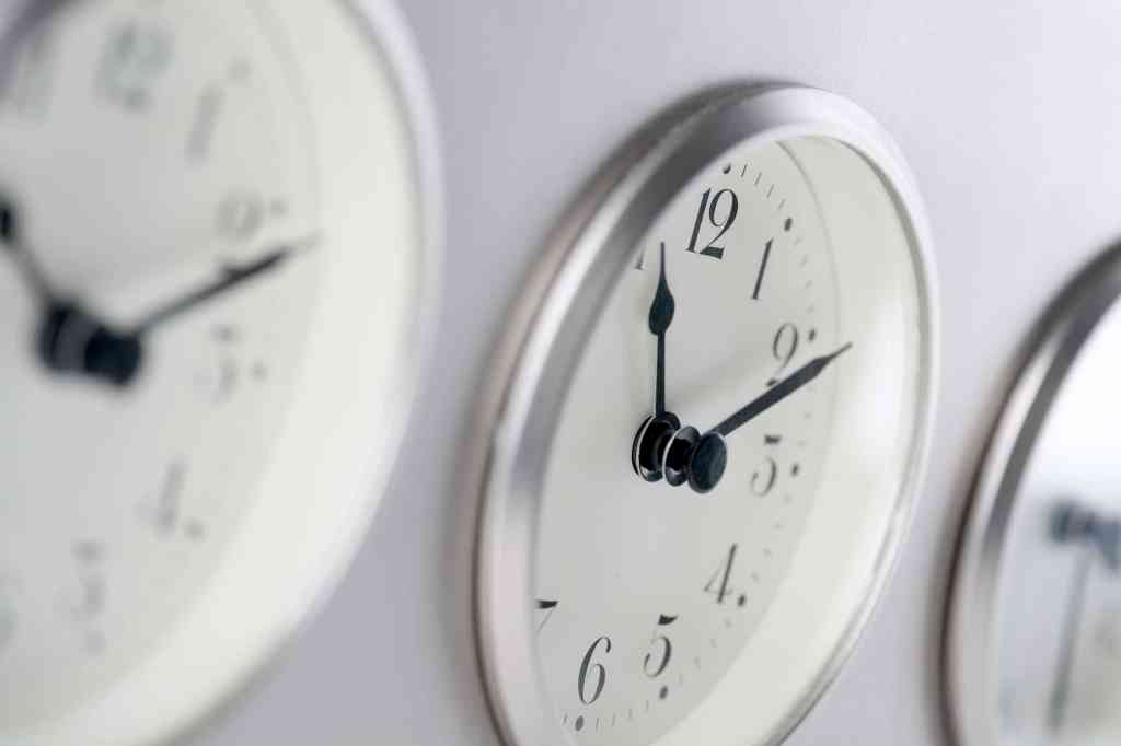Three clock faces set to different time zones