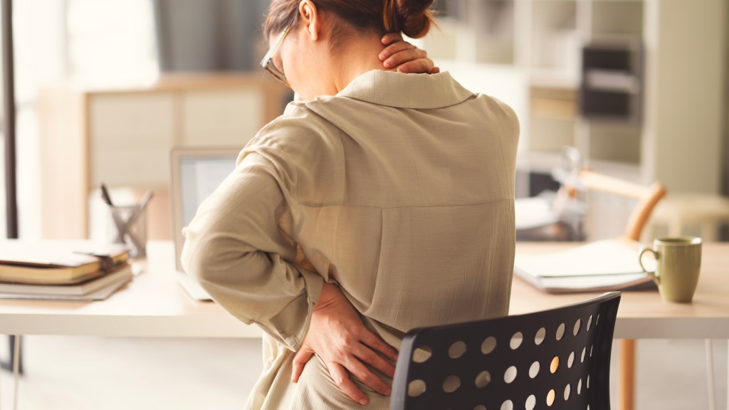 Woman holding neck and back